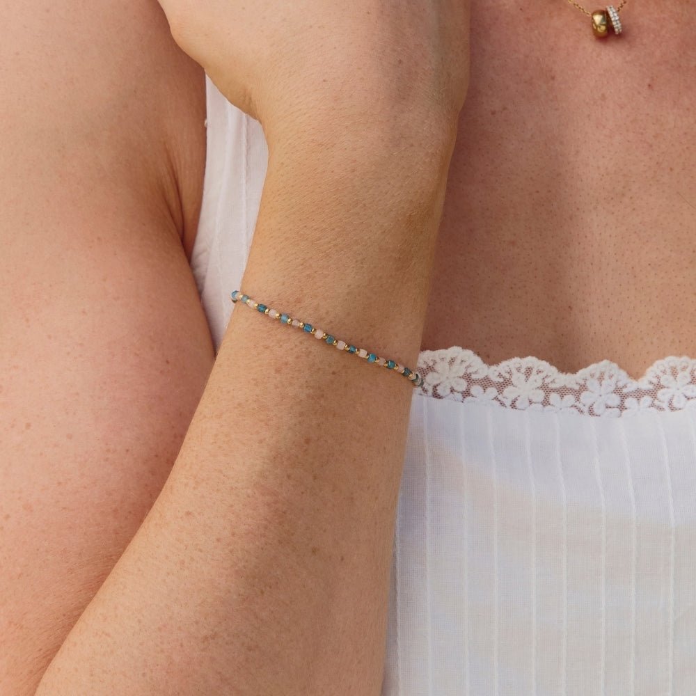Alashan Blue Bead Bracelet, worn on a wrist with a white lace-trimmed top