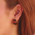 Amber Gold Hoop Earrings, worn on an ear with red hair, close-up, brown tortoiseshell with gold rim