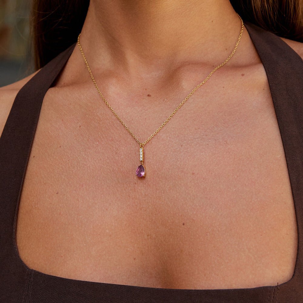 Crystal Pink Teardrop Necklace, worn on a neck over a brown top, pink teardrop pendant